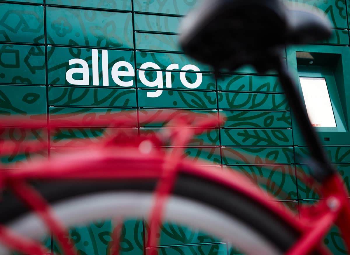 An Allegro parcel locker from the official brand press materials, a red bicycle parked in front